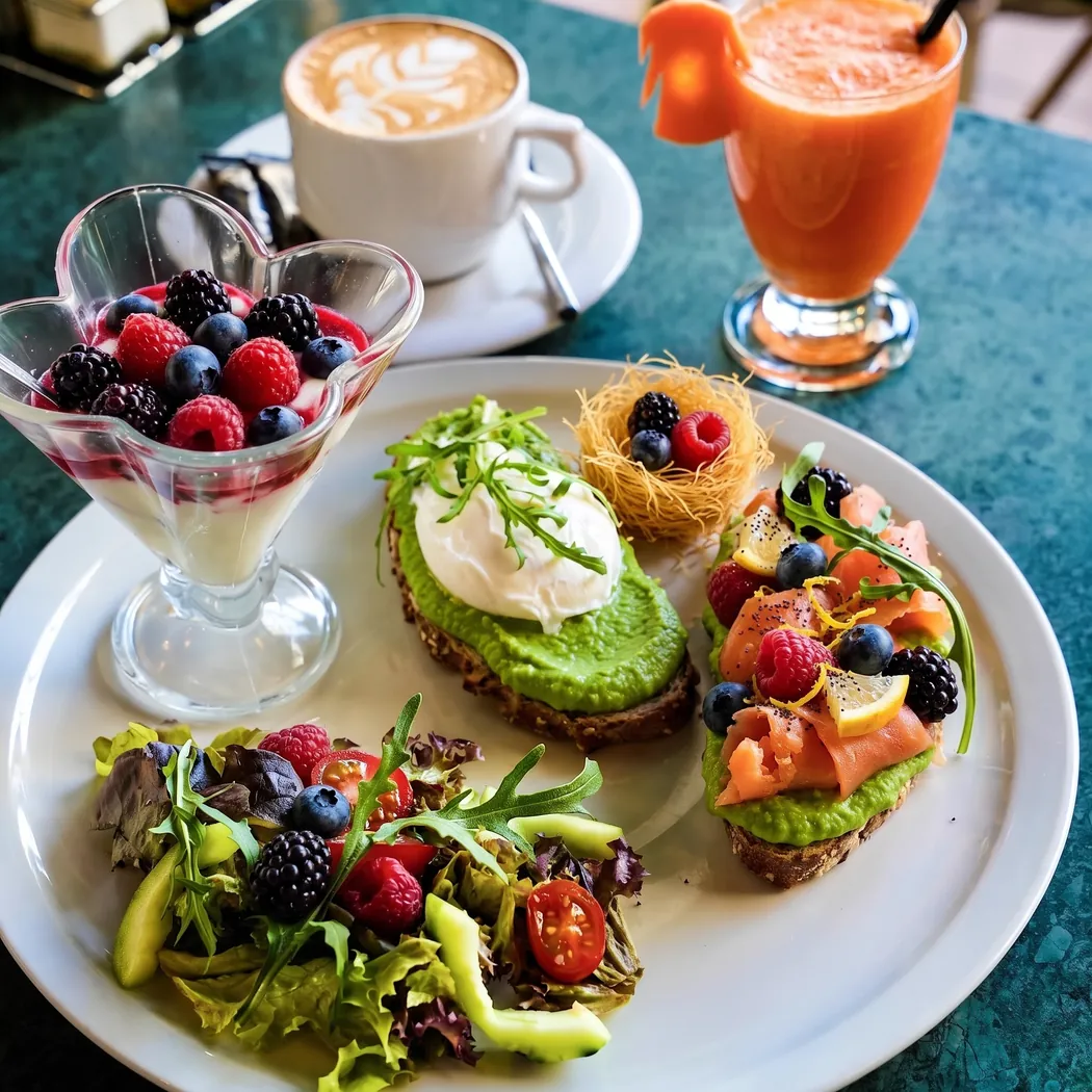 Assiette de brunch au Vendôme : tartines avocat, œuf poché, saumon, verrine de fruits rouges et jus