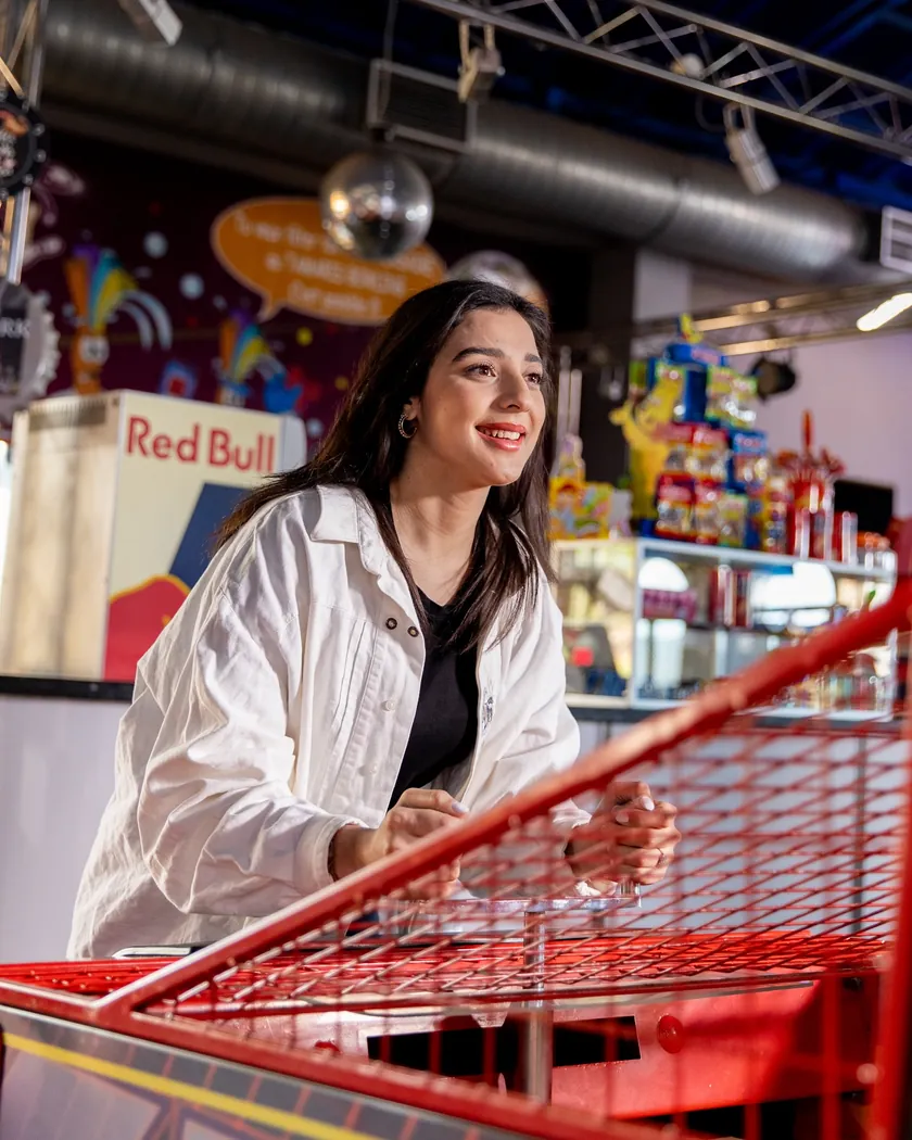 Jeune femme souriante devant un jeu d'arcade à Tamaris Bowling