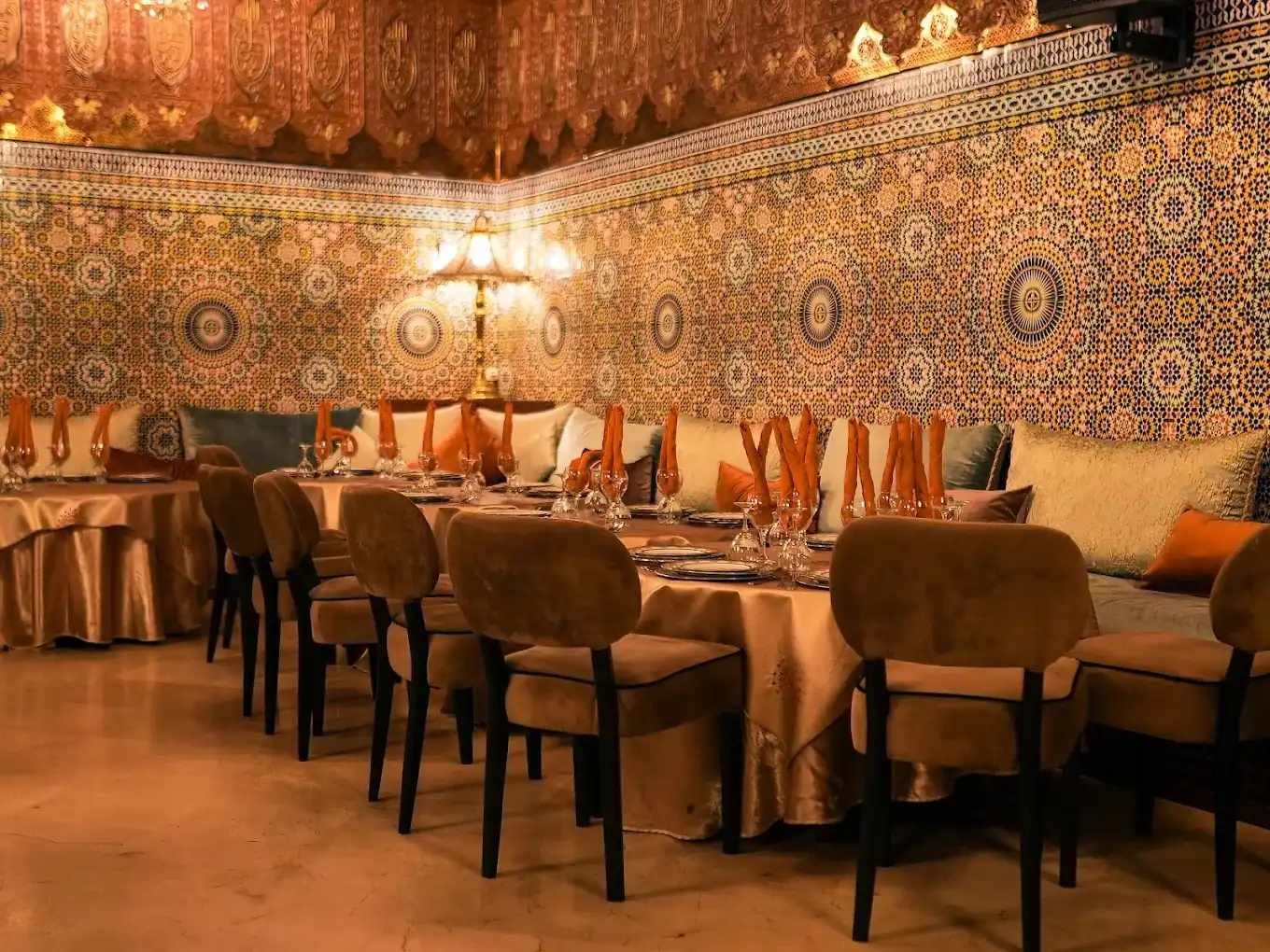 Tables et banquettes de Dar Essalam devant des murs couverts de zellige