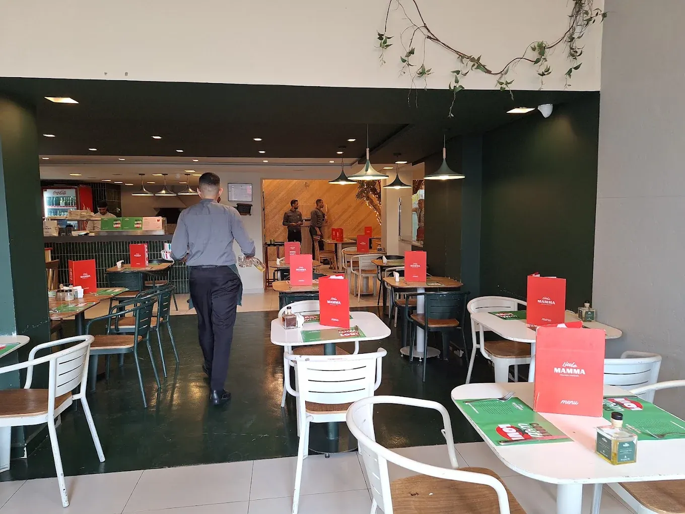 Little Mamma Agdal à Rabat : salle aux chaises blanches, menus rouges sur les tables et murs vert sombre
