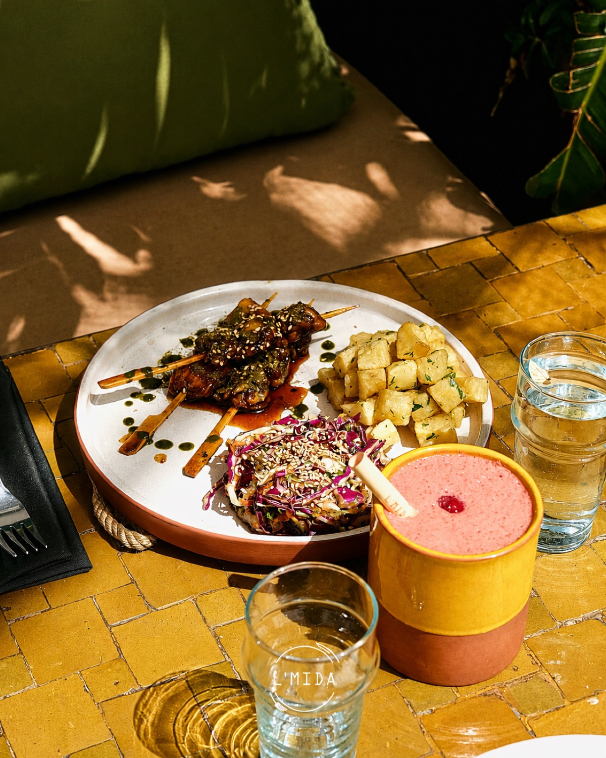 Brochettes et pommes de terre servies sur zellige jaune chez L'Mida