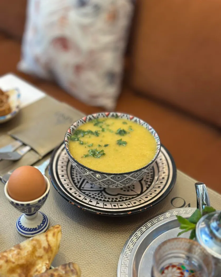 Soupe, œuf dur et thé à la menthe sur une table de Tajino