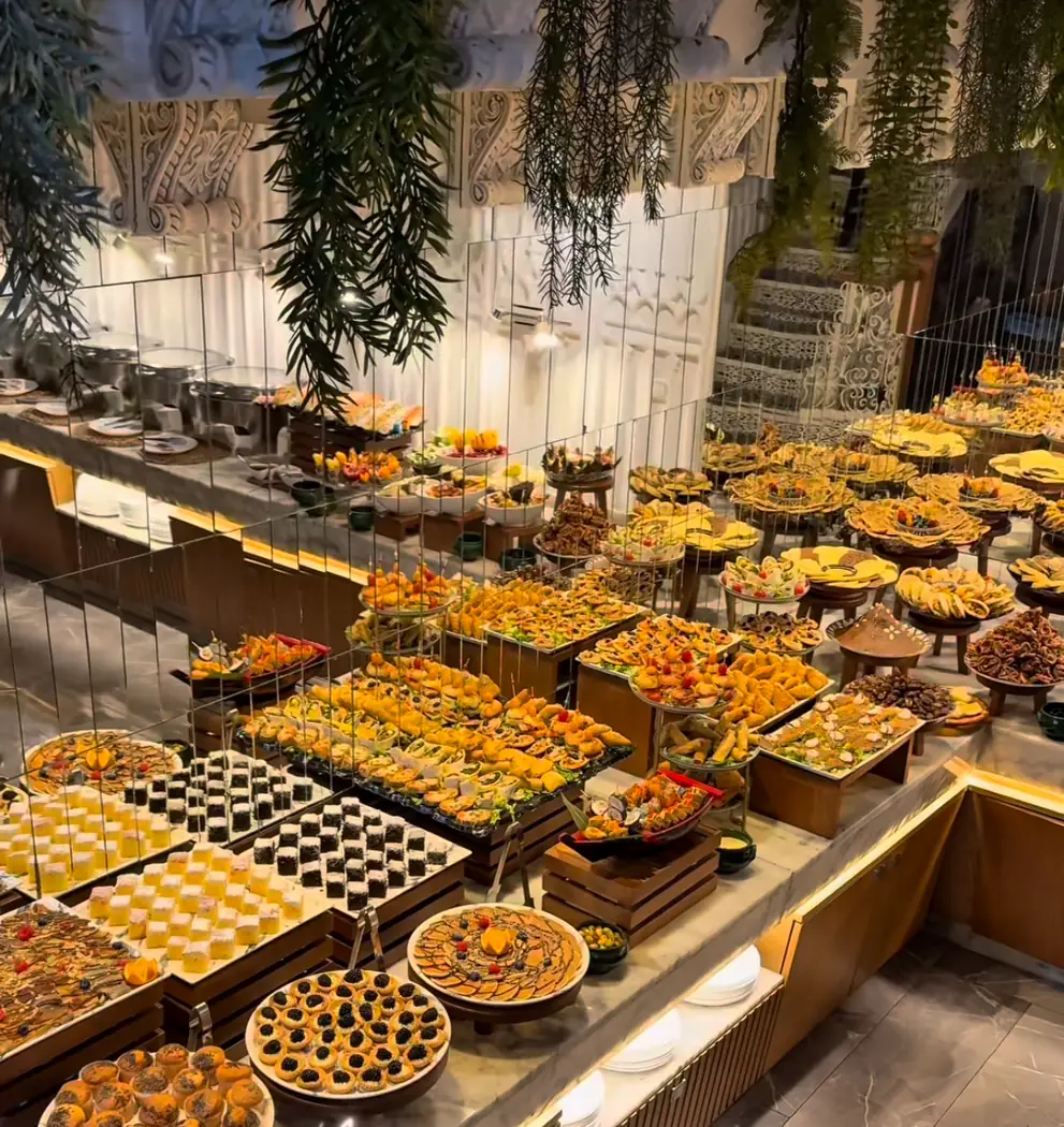Buffet de pâtisseries et de mignardises dressé dans une grande salle, photo de la fiche de Pensée à Marrakech
