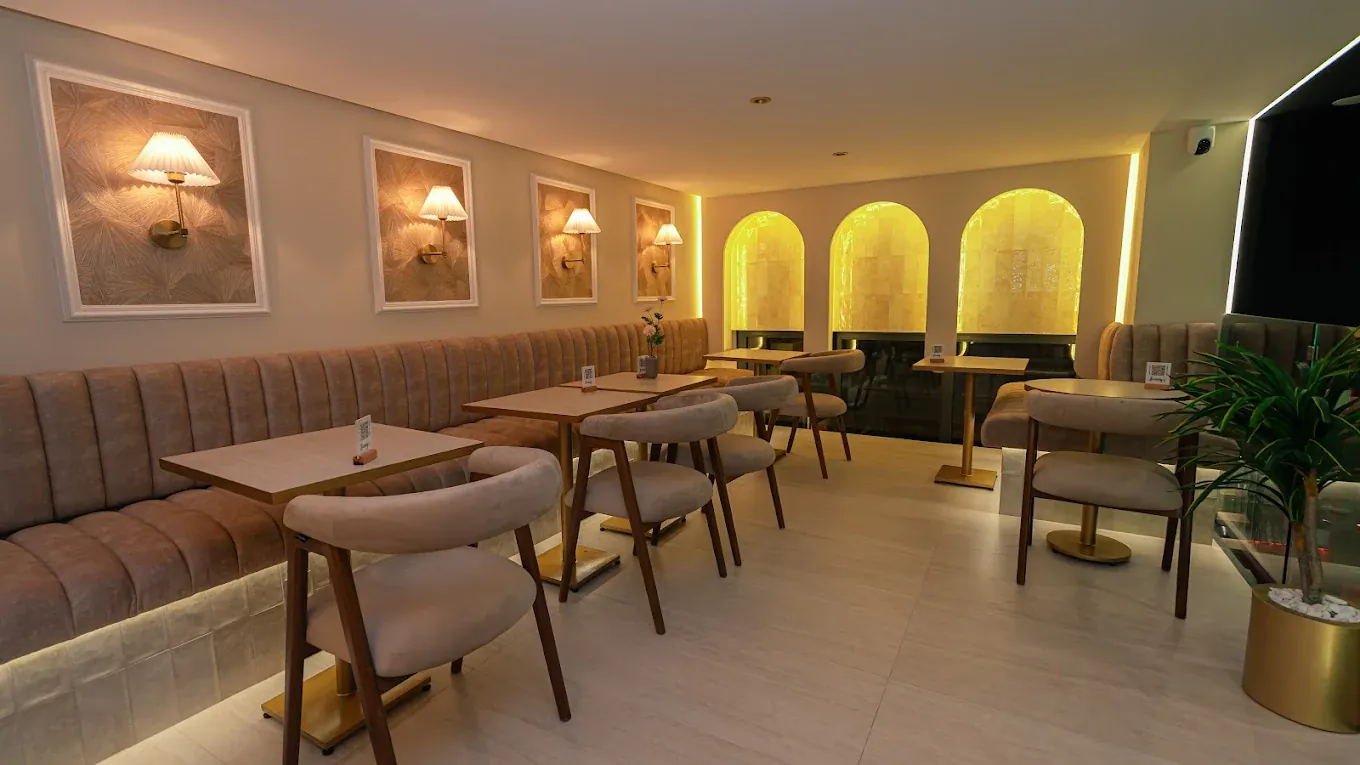 Salle de Benny's avec banquettes capitonnées, appliques et niches lumineuses