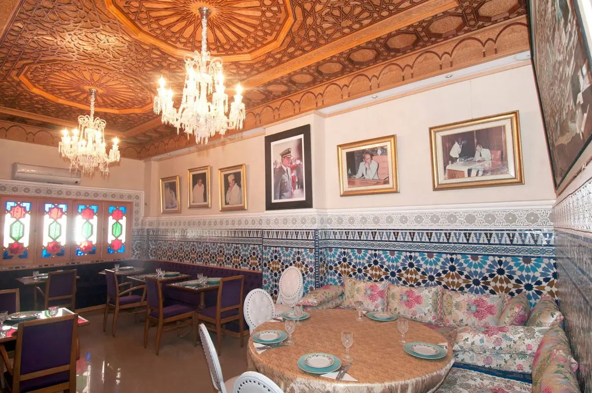 Salle du Cuistot Traditionnel à Casablanca : plafond en bois sculpté, lustres en cristal et zelliges bleus
