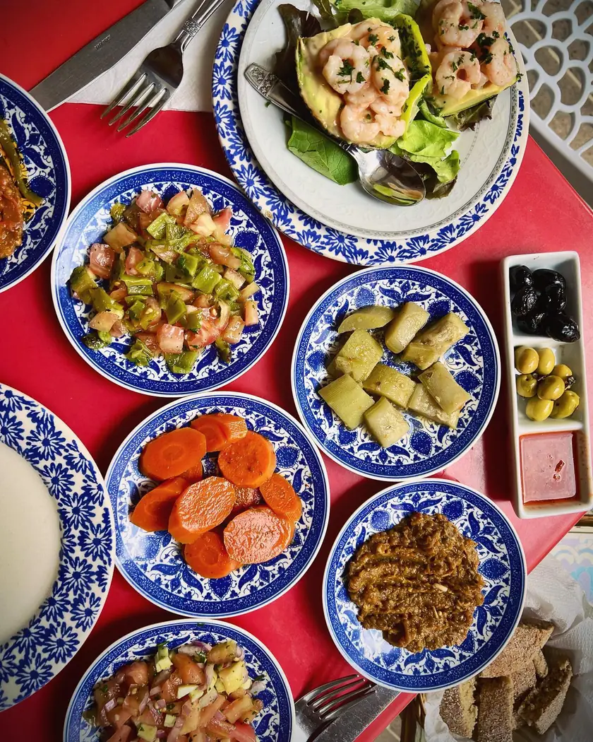 Assortiment de salades marocaines dans des assiettes bleues et blanches au Cuistot Traditionnel