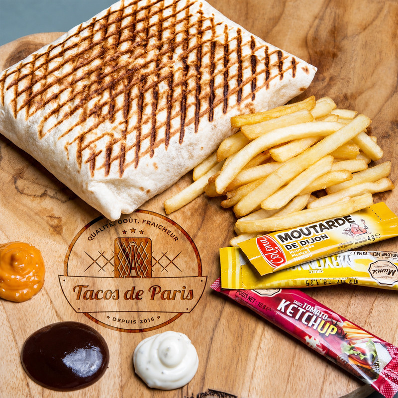 Tacos grillé et frites avec sauces sur une planche, visuel de marque Tacos de Paris