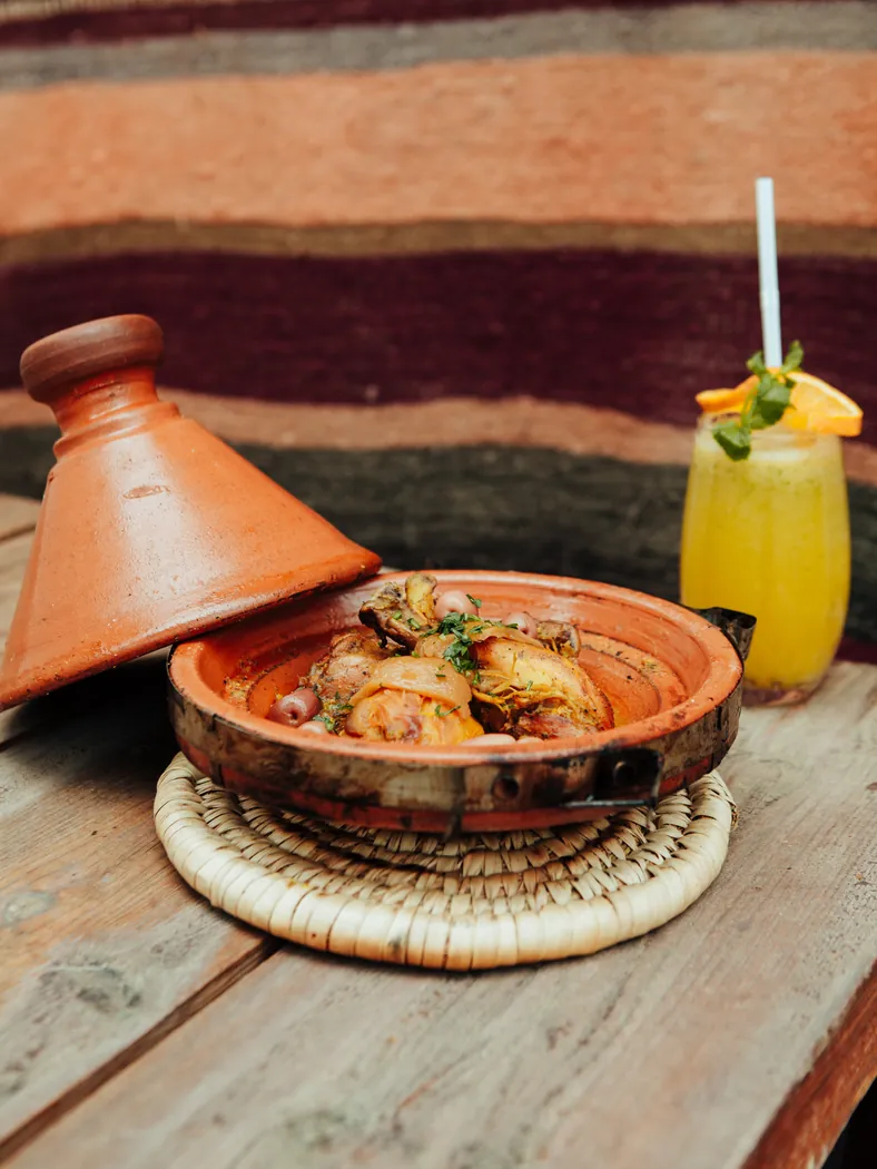 Tajine de poulet aux olives de Kui-Zin posé sur une table en bois