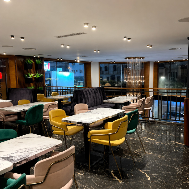 Mezzanine de Pitondoner à Casablanca, tables en marbre, chaises jaunes et baies vitrées