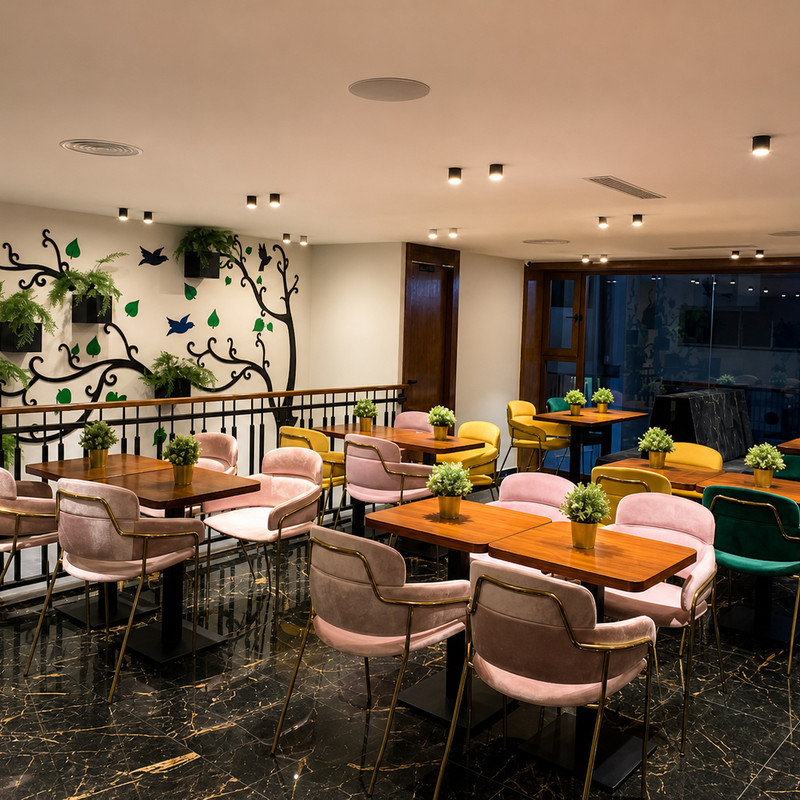 Coin salle de Pitondoner, chaises roses et fresque d'arbre au mur