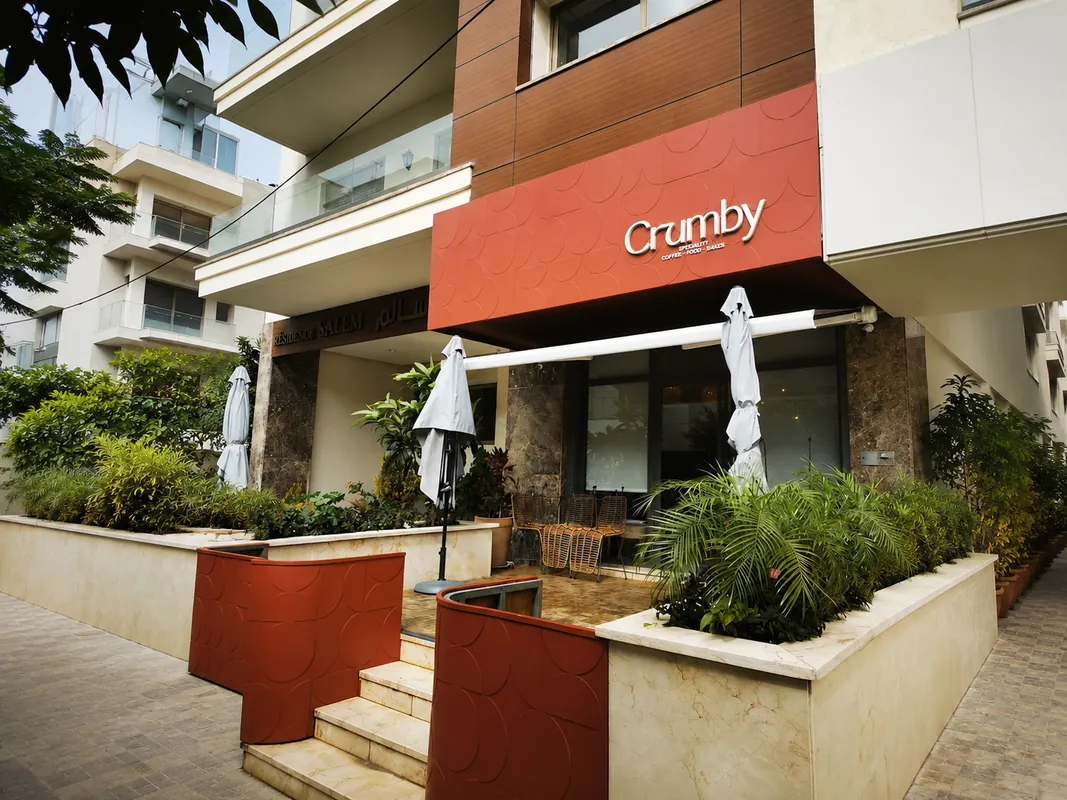 Façade de Crumby à Tanger, enseigne rouge et terrasse bordée de plantes