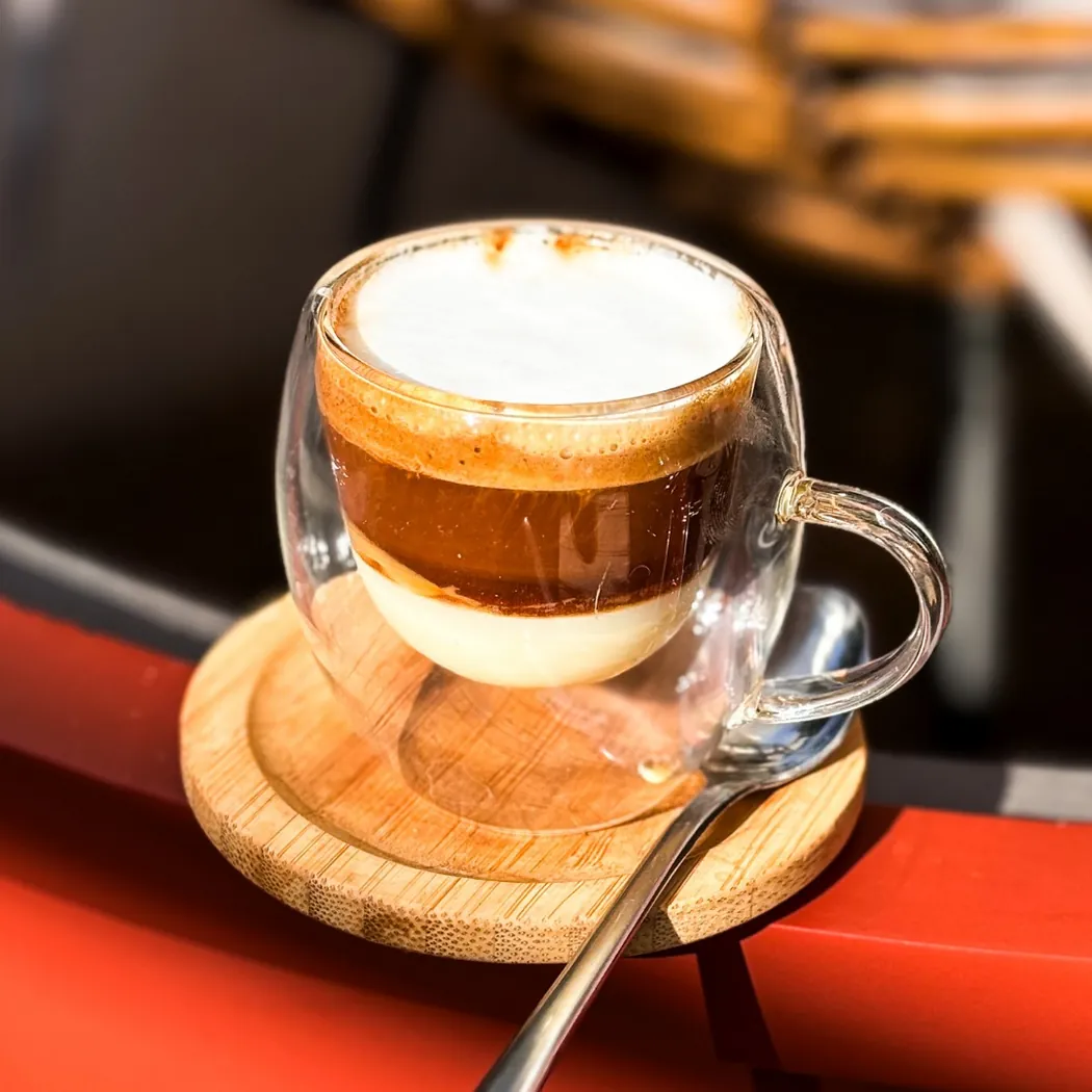 Café au lait en tasse de verre double paroi servi chez Crumby
