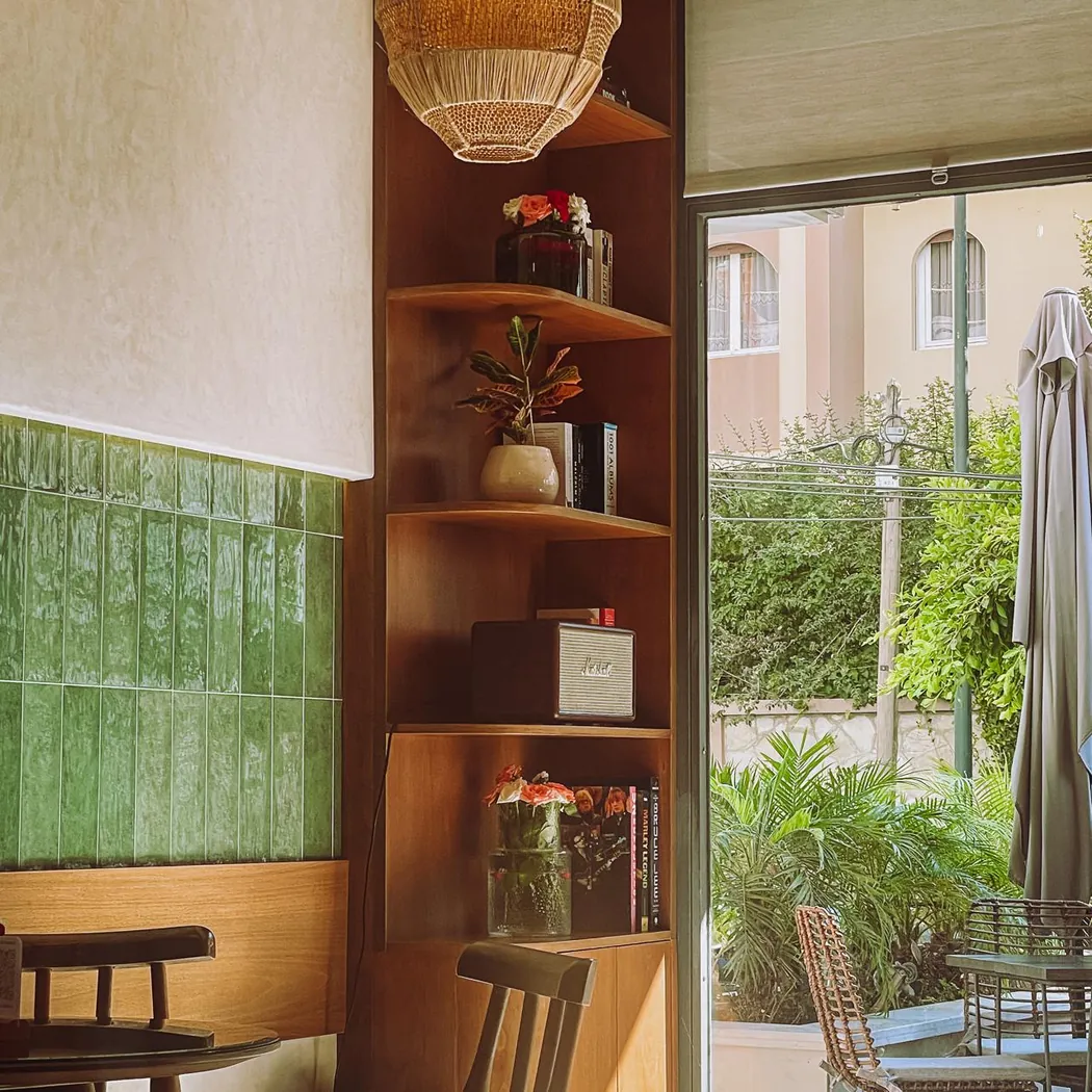 Salle de Crumby : carrelage vert, étagères en bois et porte ouverte sur le jardin