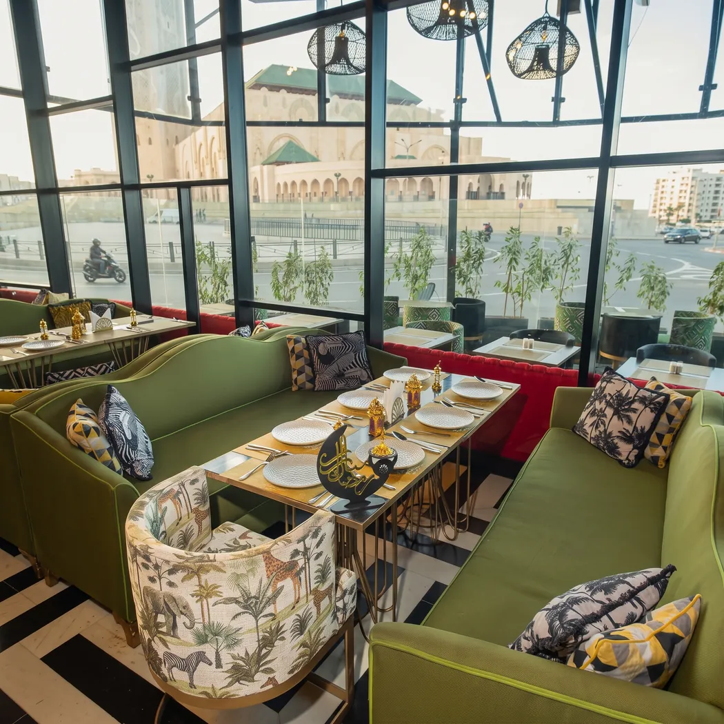 Salle vitrée du Gatsby, banquettes vertes et vue sur la mosquée Hassan II