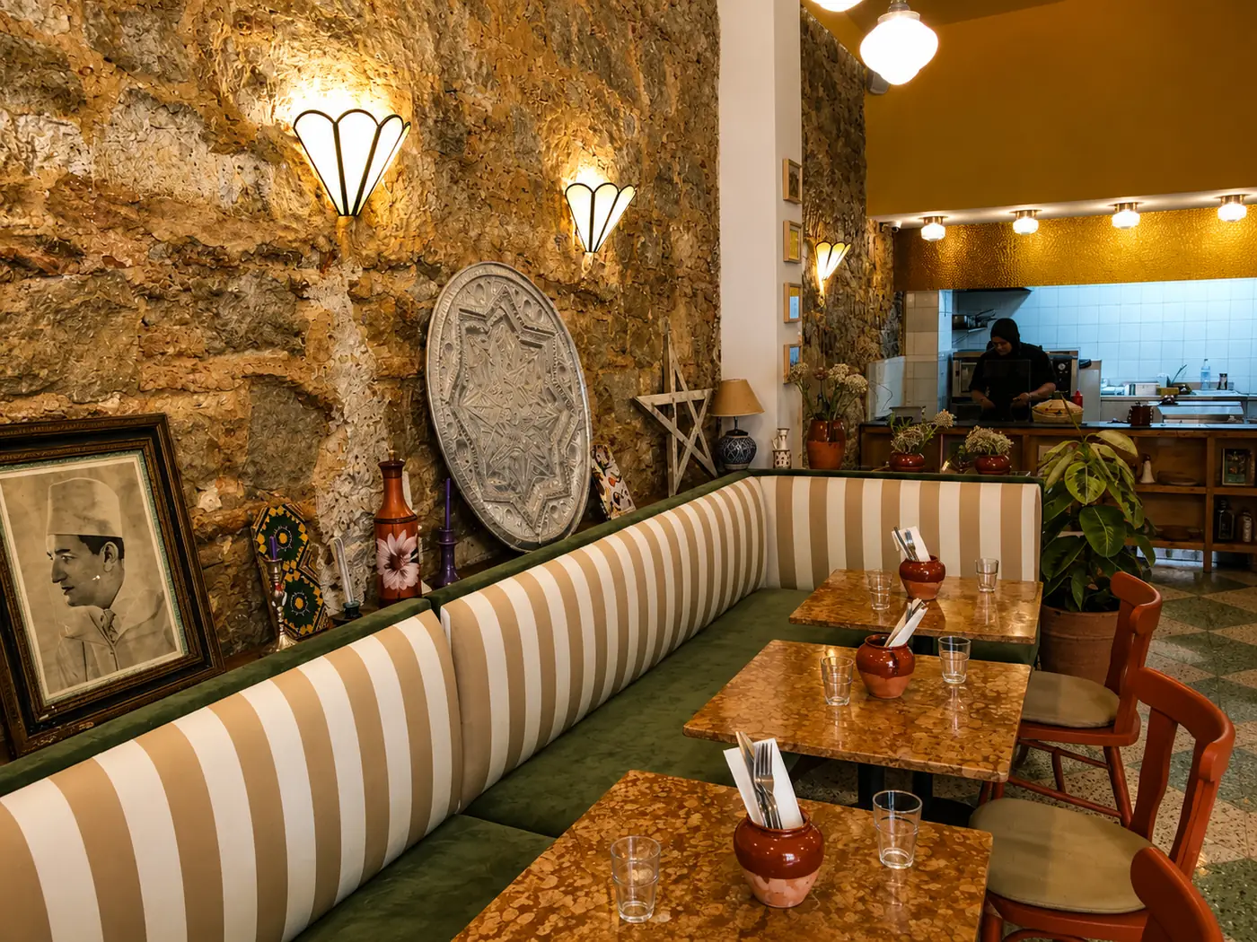 Salle de Soli à Tanger : mur de pierre, banquette rayée verte et blanche, tables en granito
