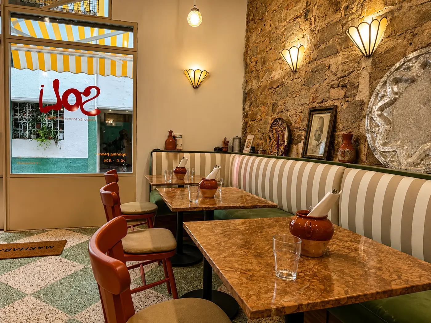 Tables de Soli devant la vitrine au logo rouge