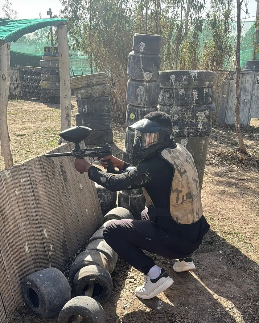 Joueur de paintball embusqué derrière des pneus au VGK