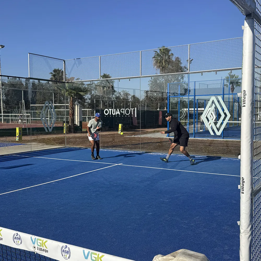 Partie de padel sur un court bleu du VGK