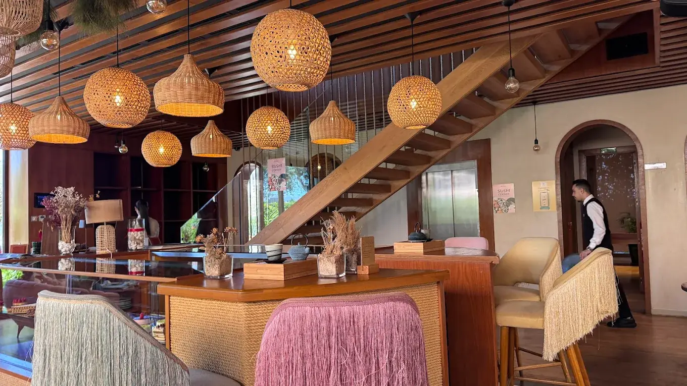 Salle de La Maison Fresh & Bio : bar en bois, tabourets à franges et lampes en rotin