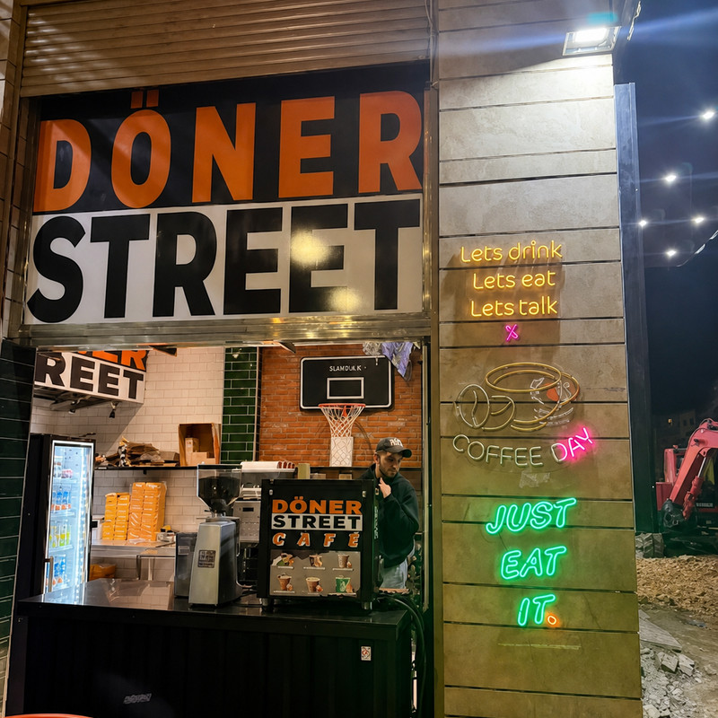 Comptoir de Döner Street de nuit, grande enseigne orange et noire et néons verts