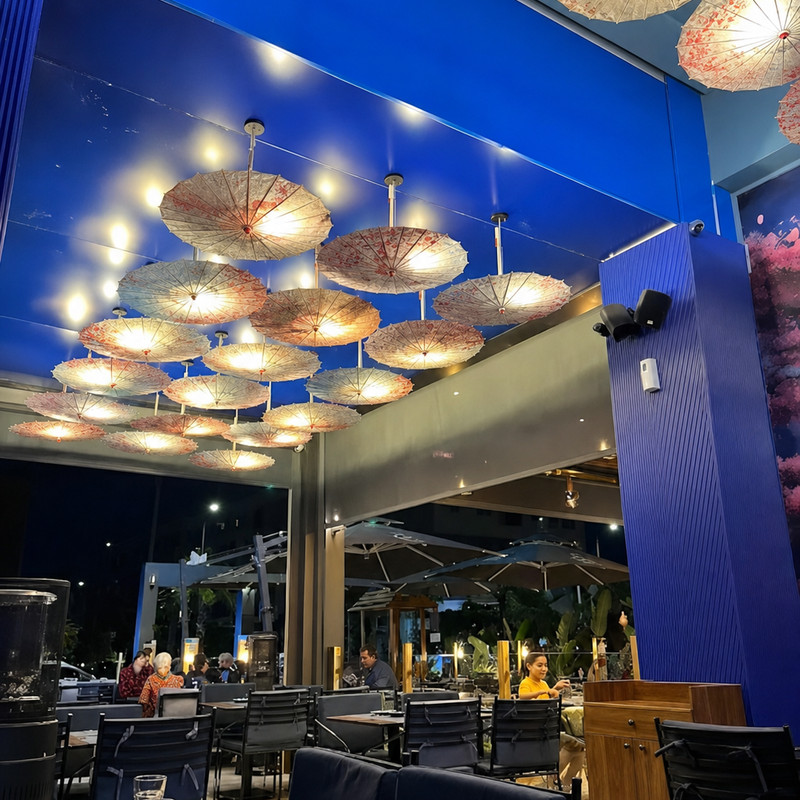 Terrasse couverte de HySushi Izdihar à Marrakech, sous des ombrelles suspendues éclairées