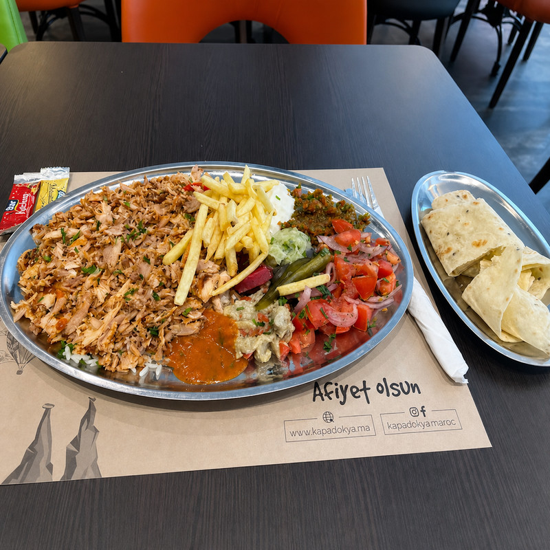 Assiette de chawarma, frites et crudités avec pain plat sur une table de Kapadokya à Agadir