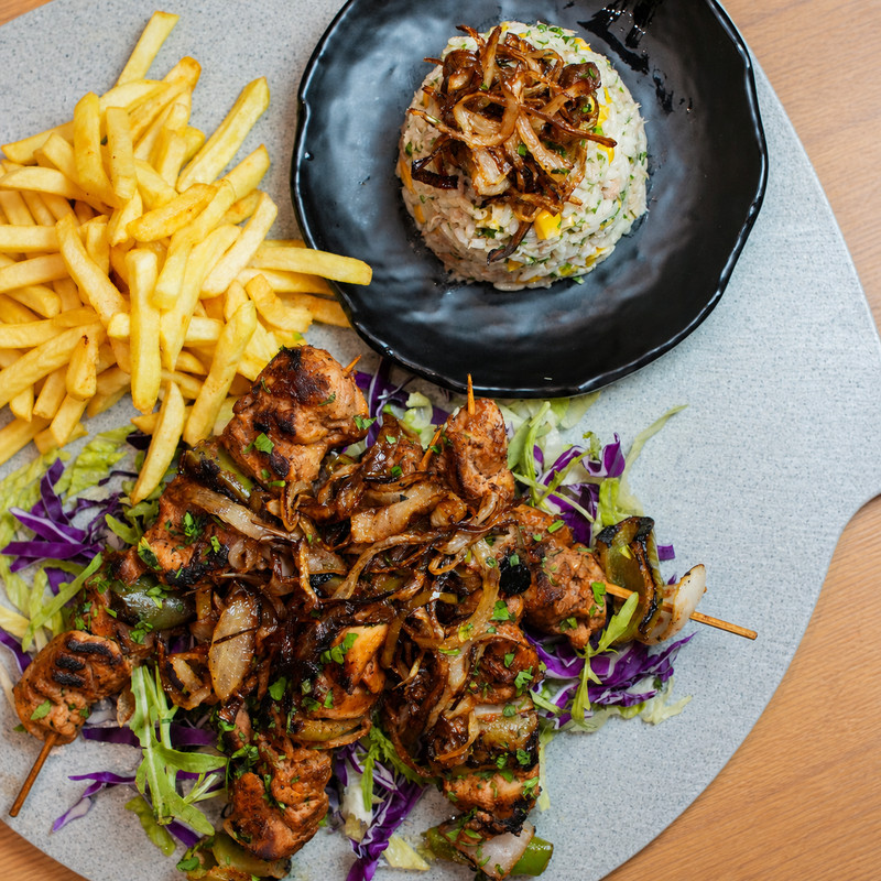 Brochettes de poulet grillé, frites et riz servis chez Shawarma Al Haram