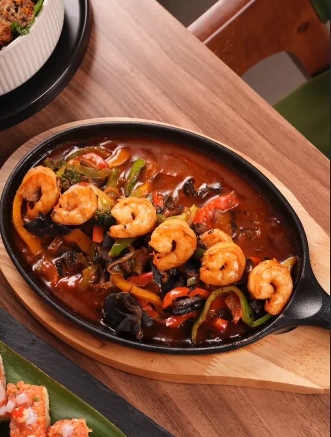 Crevettes sautées aux poivrons et champignons noirs servies en poêlon chez Myōgi, Marrakech