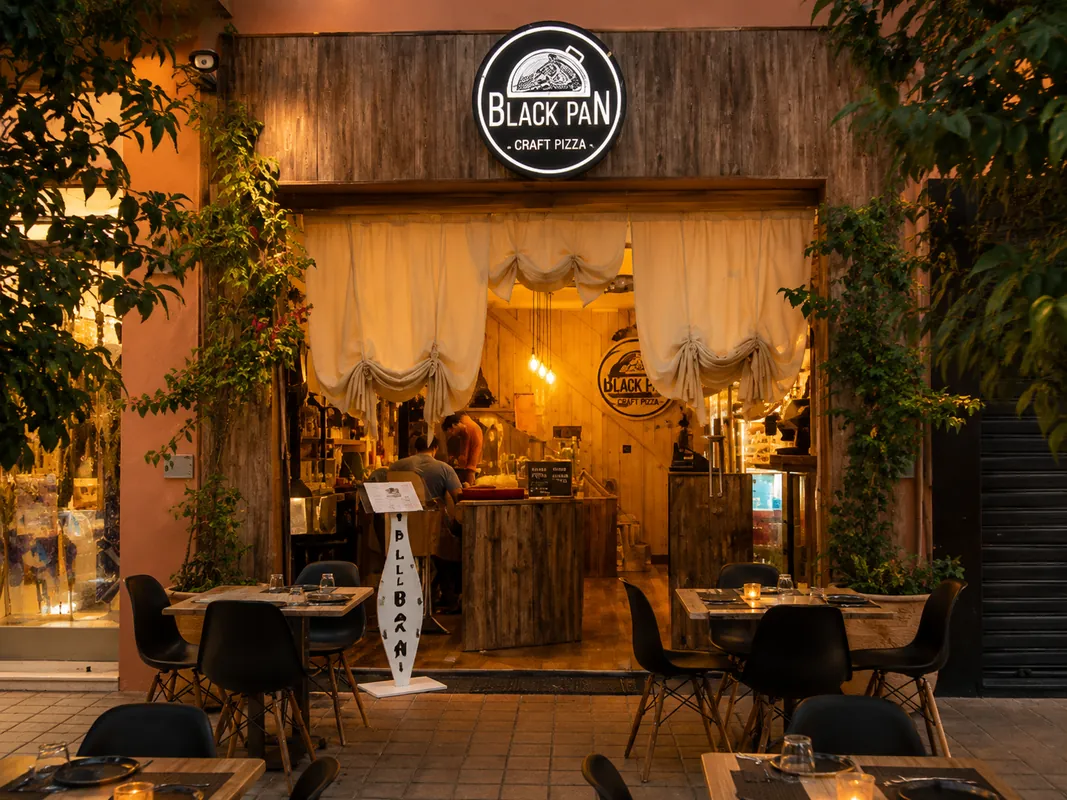 Black Pan à Marrakech : façade de la pizzeria le soir, terrasse sur le trottoir rue Ibn Toumert