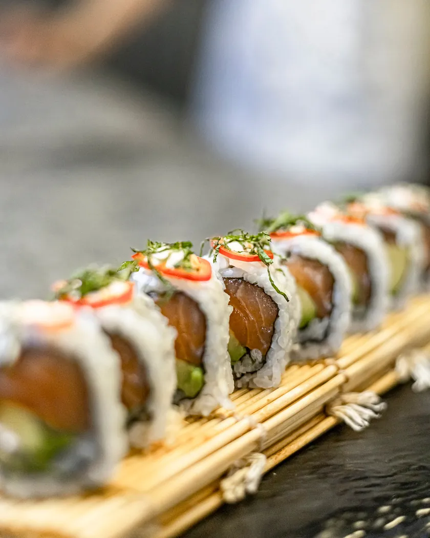 Rouleaux de saumon et avocat alignés sur une natte de bambou chez Ô'Sushi Lounge