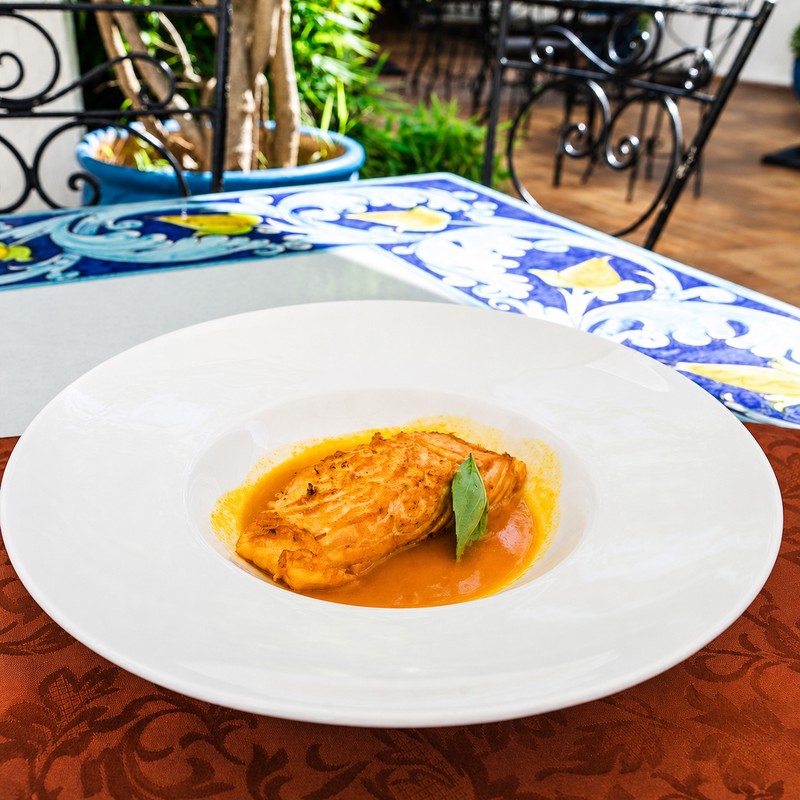 Il Giardino à Rabat : pavé de poisson nappé de sauce tomate et basilic dans une assiette creuse
