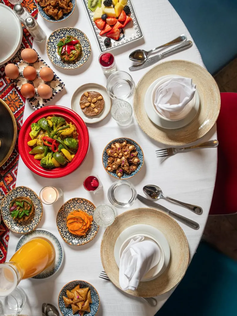 Table vue du dessus au Basmane : petits plats marocains, œufs, fruits secs et jus d'orange