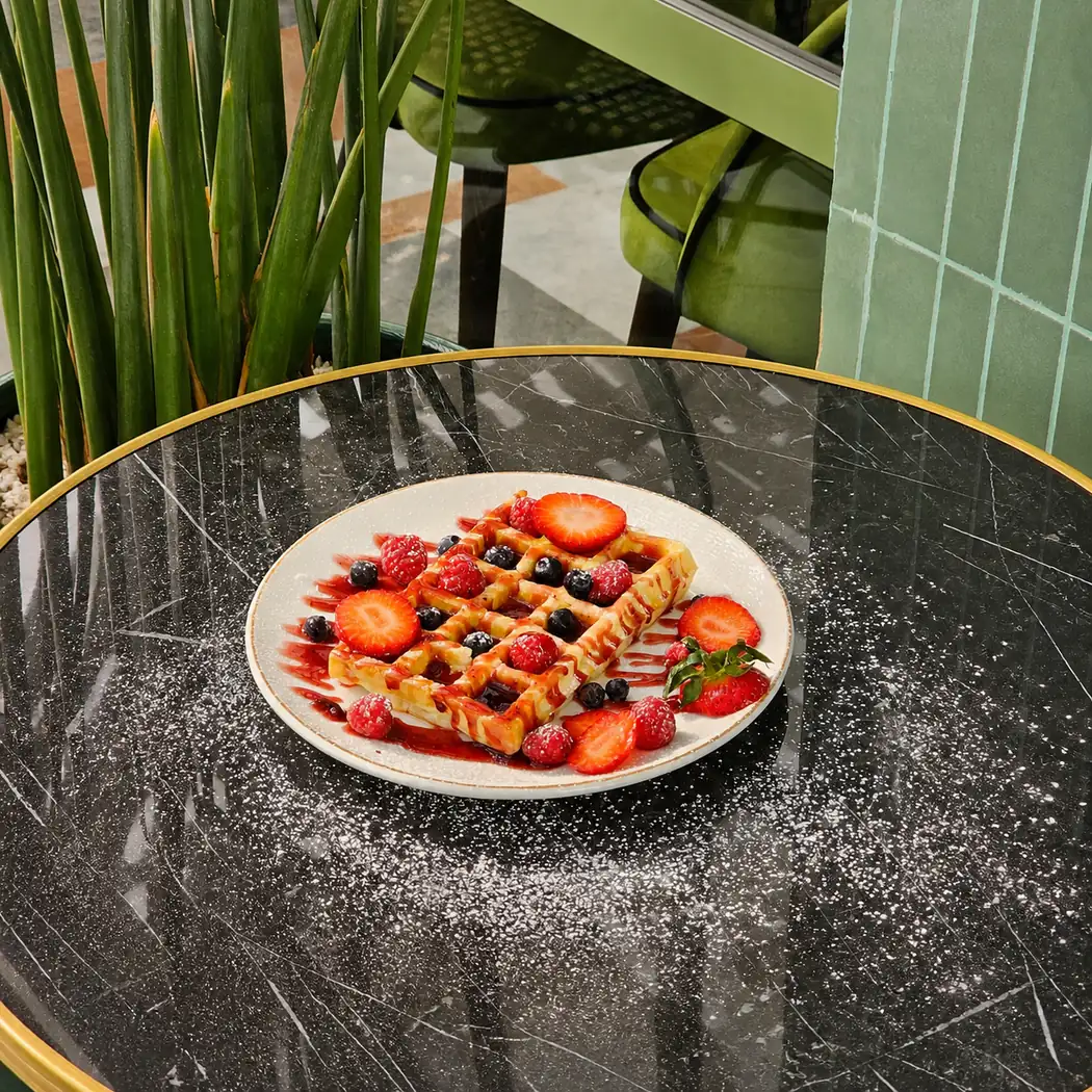 Gaufre aux fraises et fruits rouges sur une table en marbre noir