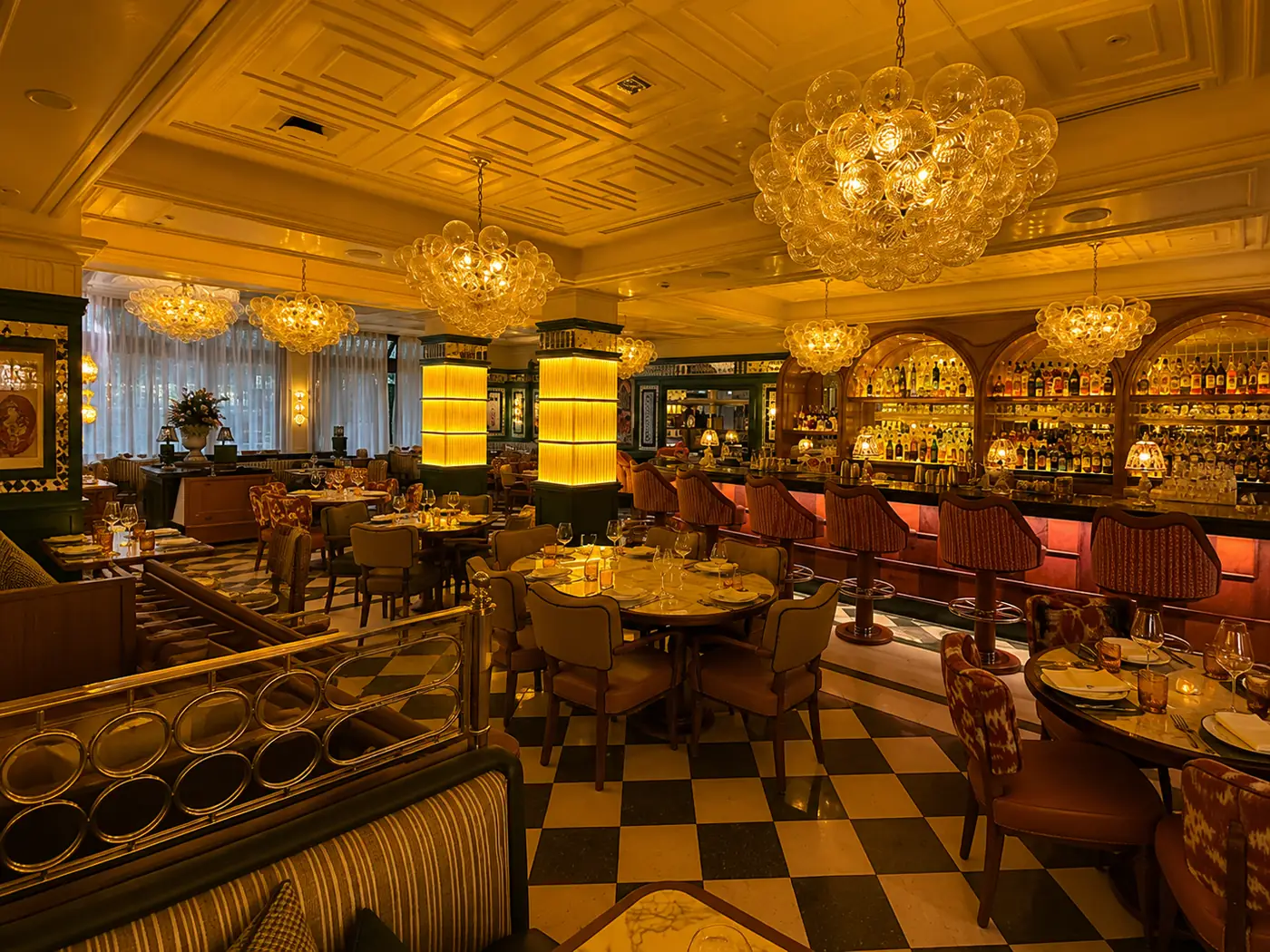 Cicchetti : salle au sol en damier, lustres à bulles de verre et bar rétroéclairé
