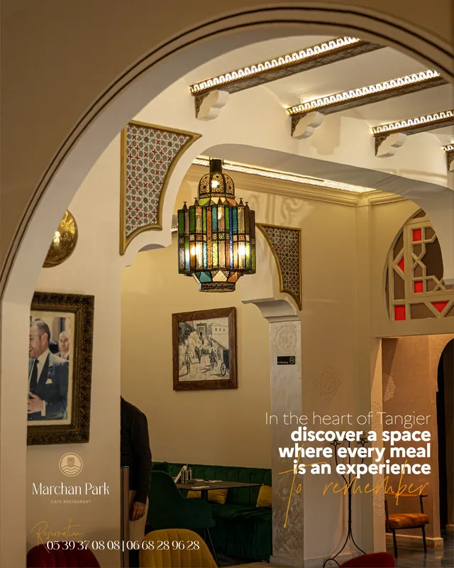 Salle de Marchan Park avec arche sculptée, zellige et lustre en verre coloré