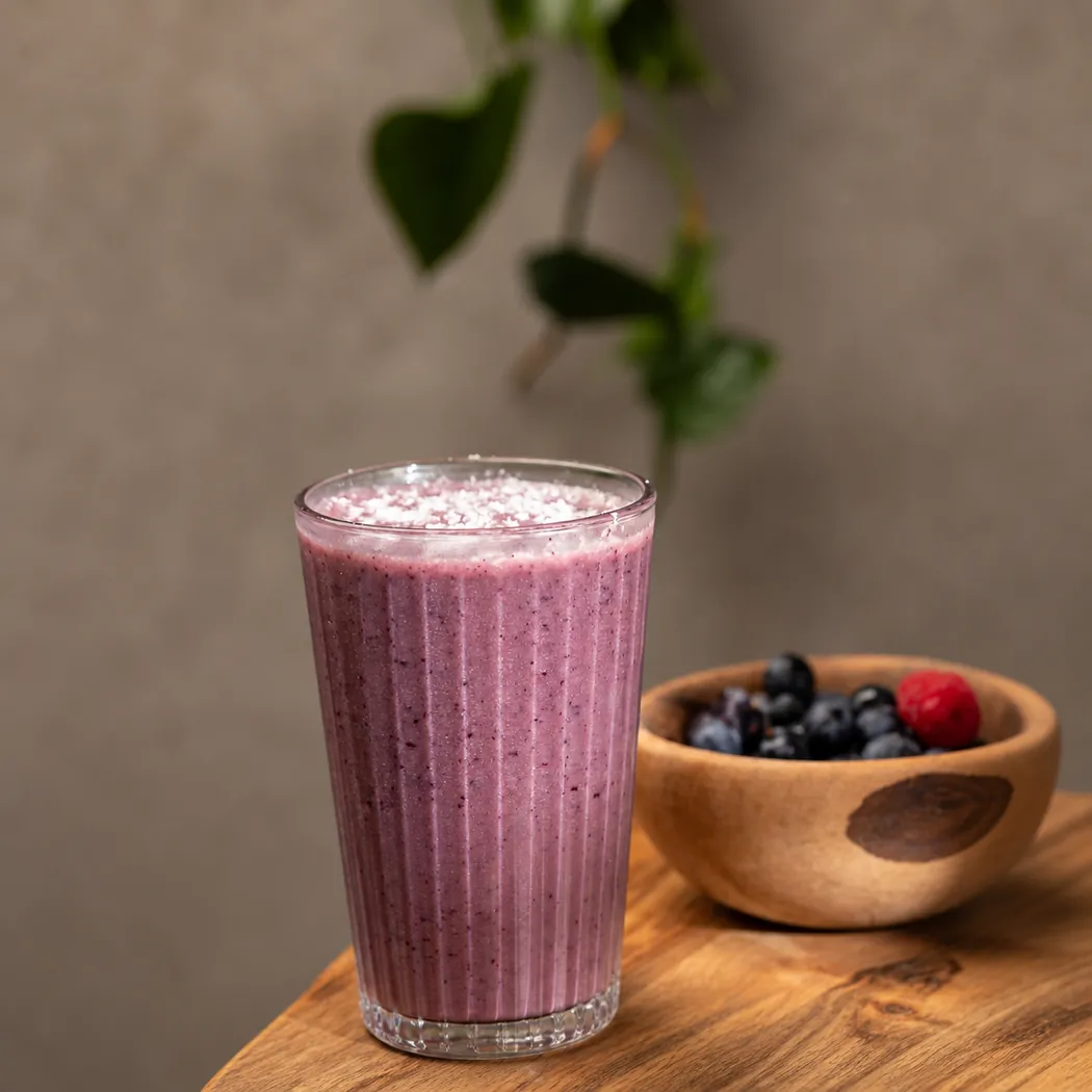 Smoothie aux fruits rouges et bol de myrtilles sur table en bois, Domus Bistro