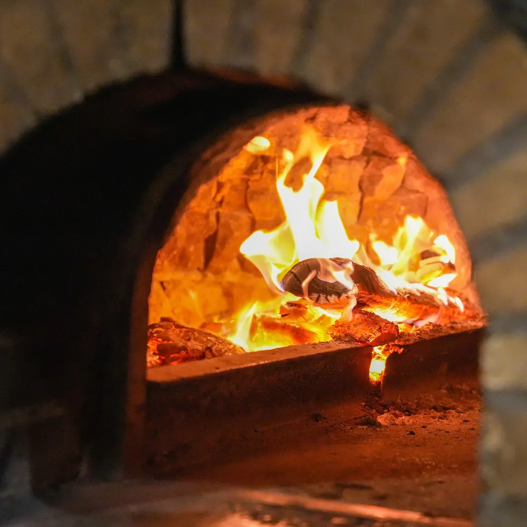 Latium à Rabat : flammes et bûches dans la gueule du four à bois