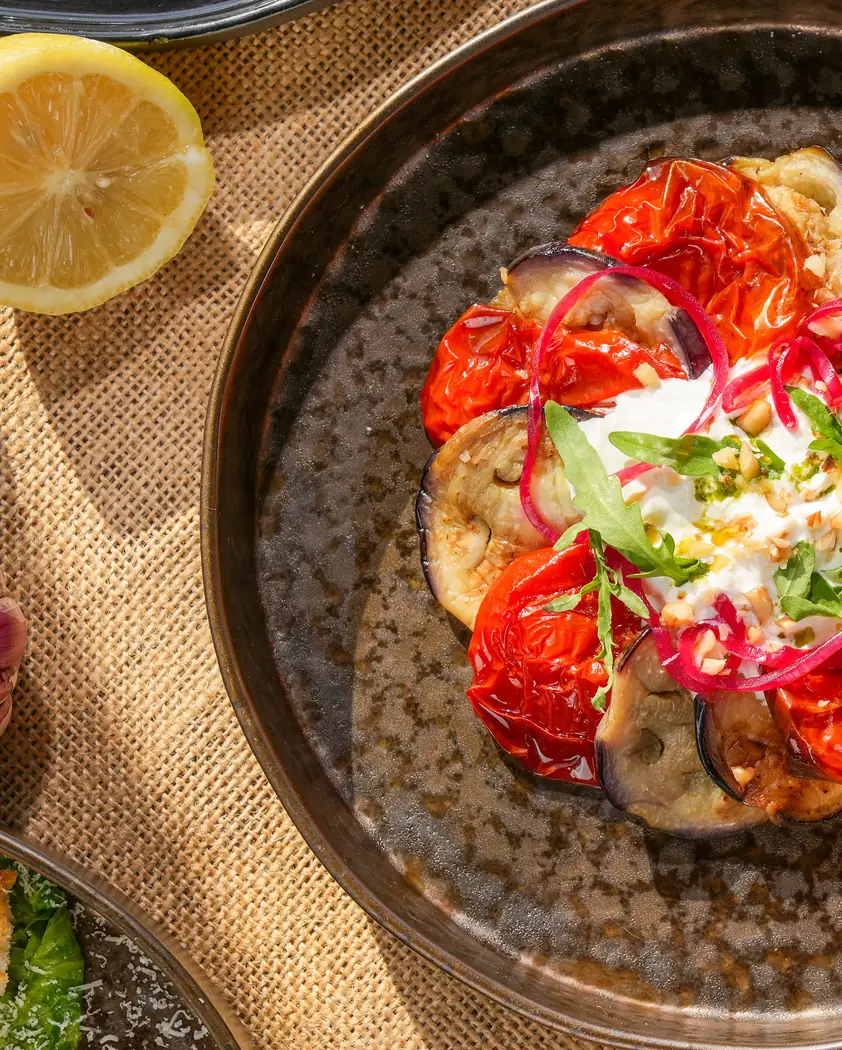 Latium à Rabat : tomates rôties, aubergines, oignon rouge et fromage frais dans une assiette
