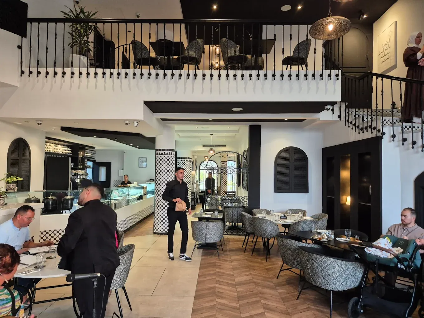 Rez-de-chaussée et mezzanine de Basidi, décor noir et blanc, clients attablés