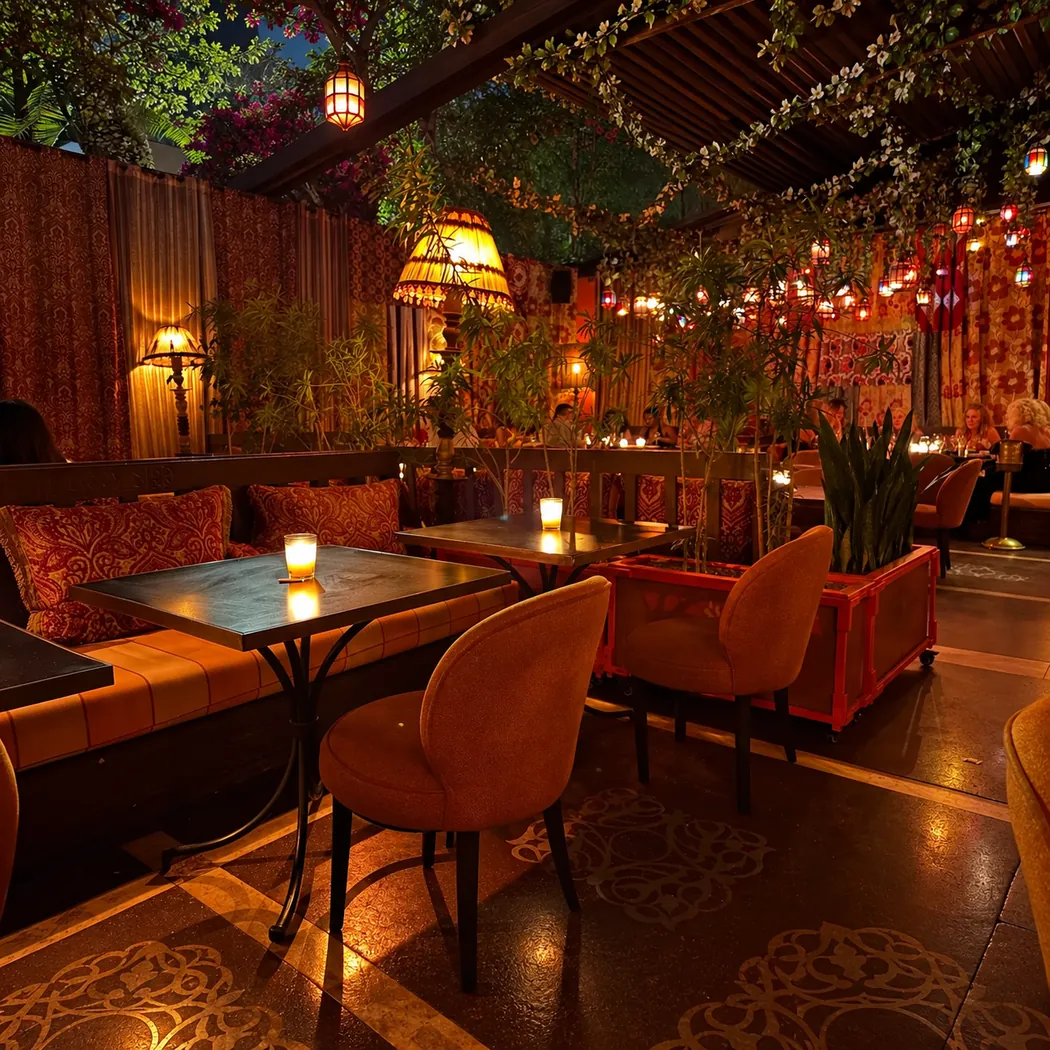 Salle du Comptoir Darna en lumière tamisée, fauteuils orange et lanternes