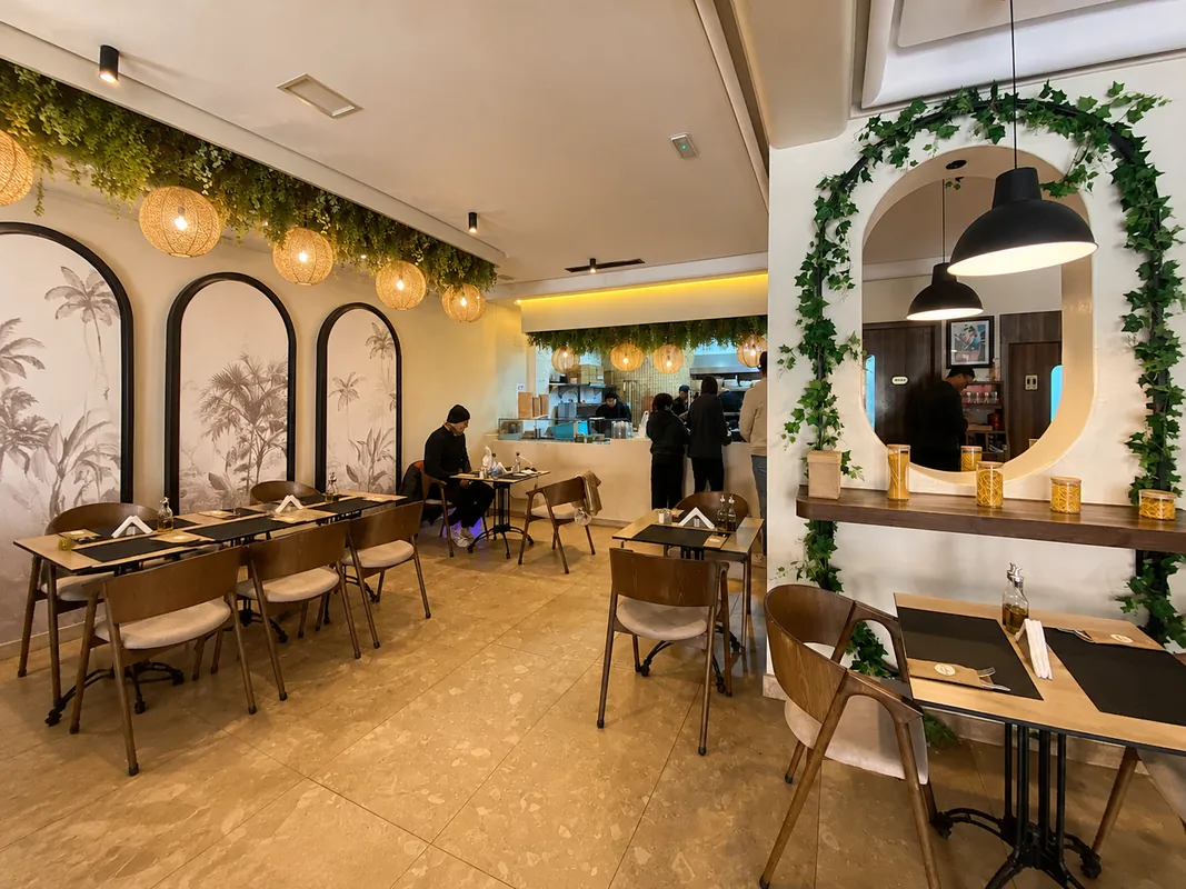 Ké Pasta à Marrakech : salle avec arches peintes de palmiers et miroir rond encadré de verdure