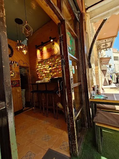 Entrée de 212pizzeria à Fès : comptoir, tabourets hauts et luminaires suspendus