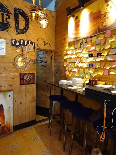 Intérieur lambrissé de bois de 212pizzeria, mur couvert de post-it laissés par les clients