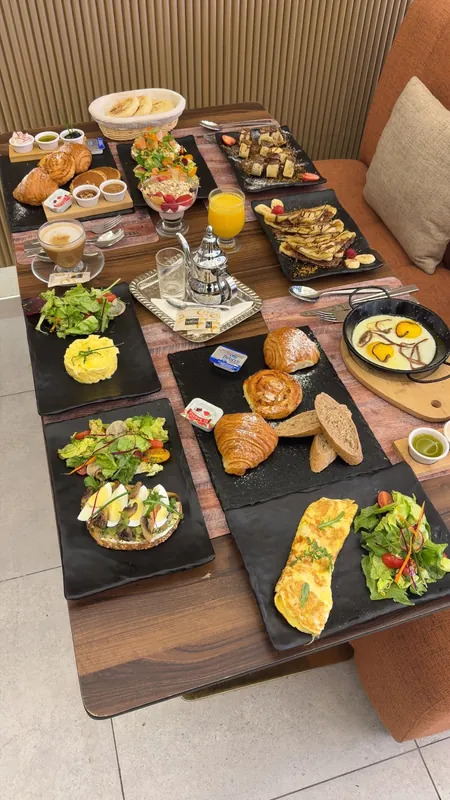 Table garnie de petits-déjeuners, salades et omelettes au restaurant Le Pavé à Marrakech