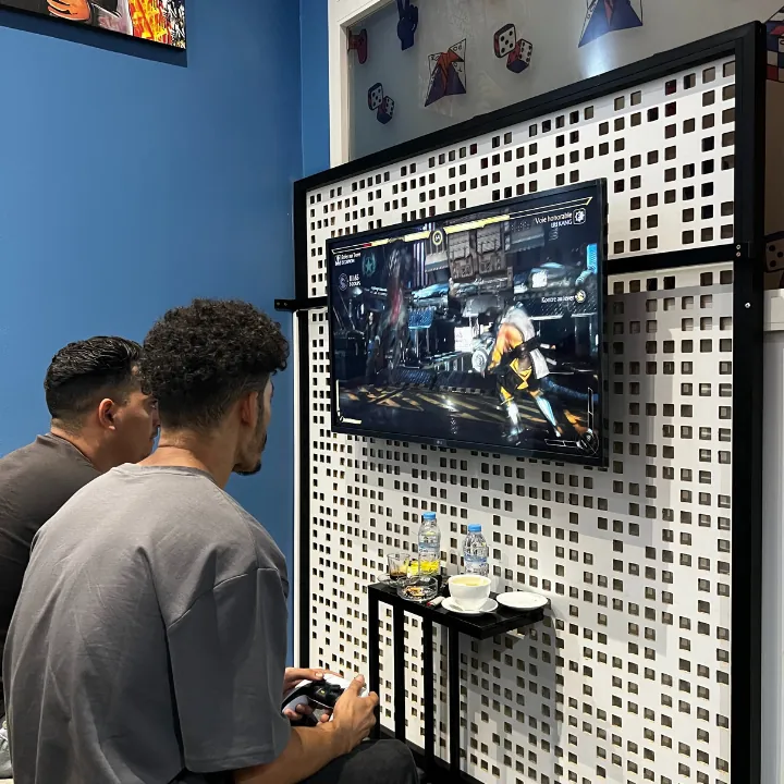 Deux joueurs face à un écran de jeu vidéo chez Pixel & Play