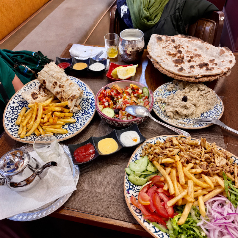 Table garnie chez Kabab Erbil : pain cuit, chawarma, frites, salade, caviar d'aubergine et thé