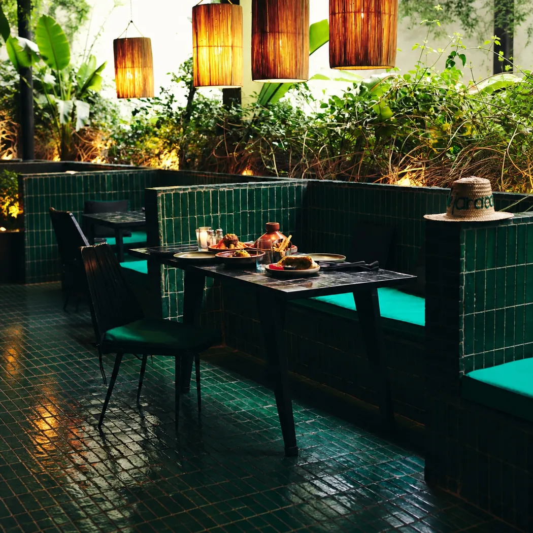 Banquettes en zellige vert et lanternes en osier au Jardin