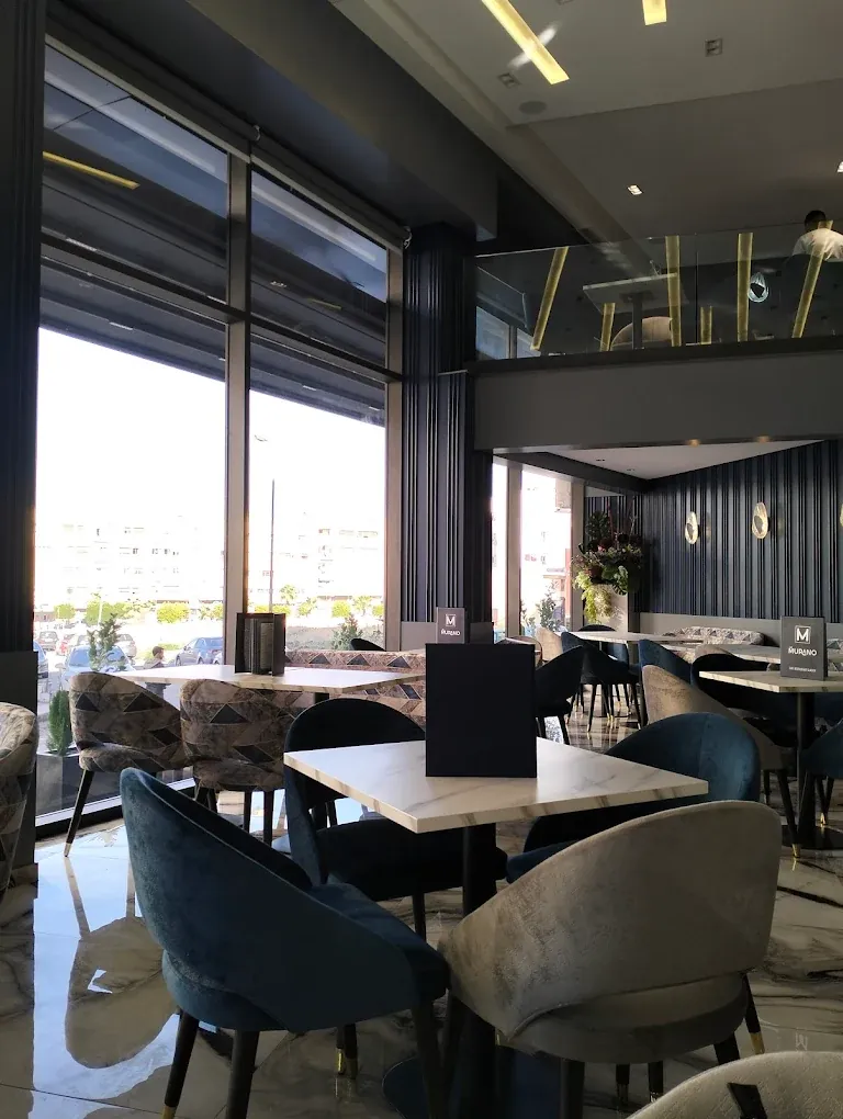 Salle du Murano à Fès : baies vitrées, fauteuils en velours bleu et tables en marbre