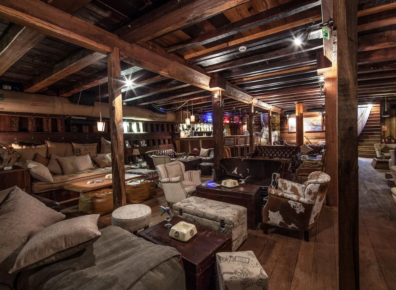 Salon intérieur du Dhow : poutres en bois, canapés et fauteuils en cuir