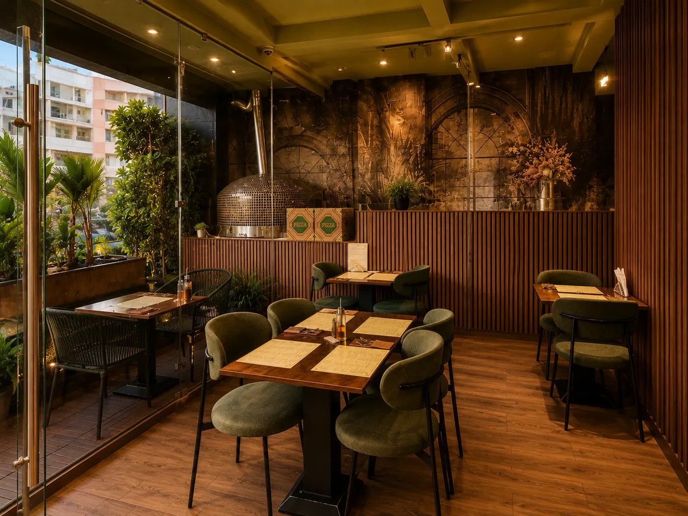 Eatalia à Rabat : tables et chaises vertes sous une baie vitrée, four à pizza en mosaïque au fond